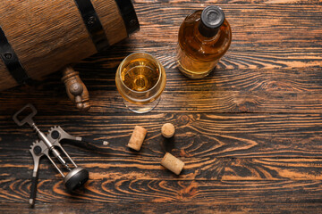 Oak barrel, bottle and glass of exquisite wine on wooden background