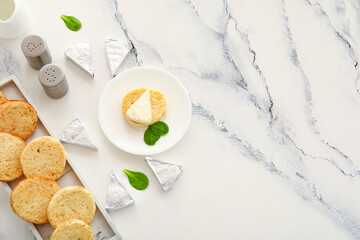 Plates with croutons and triangles of tasty processed cheese on white marble background