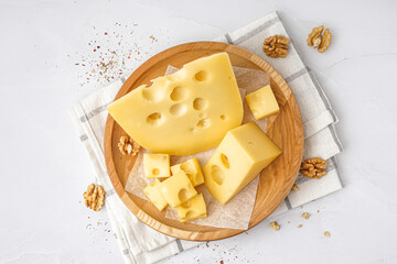 Plate with pieces of Swiss cheese and walnut on white background