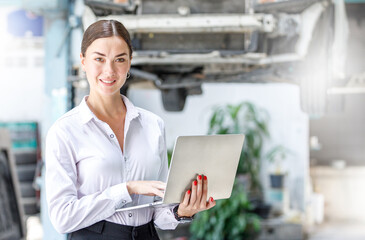 business woman Use the garage laptop to search for information, check the condition of the car....
