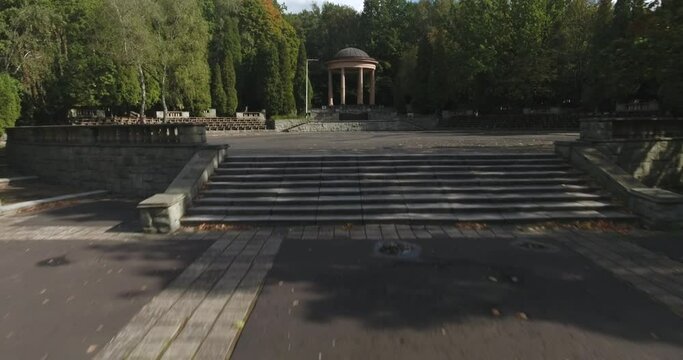 Dance circle with historic building in a city park in summer in Poland. Dynamic 4K drone footage.