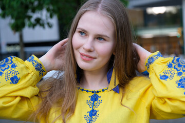 the hands of a young girl hold the Ukrainian flag. A girl in an embroidered shirt. free Ukraine. High quality photo