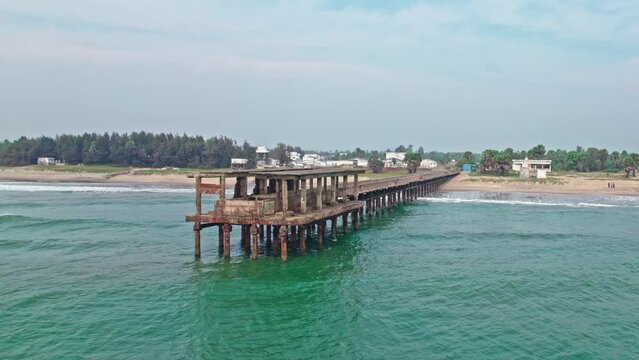 abandoned walking bridge in to the sea lay to ruins drone shot addaripeta beach 4k
