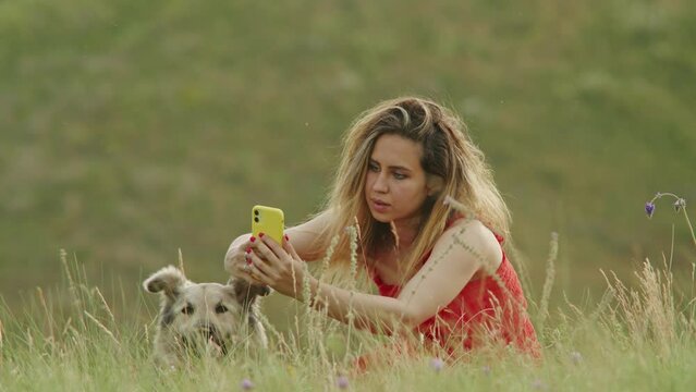 taking care of pets, a girl takes a selfie photo with a dog in nature, the happiness of uniting a person and an animal