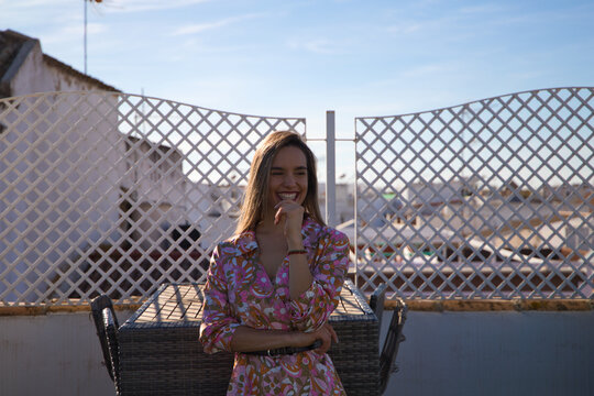 Young and beautiful blonde woman on the roof of a building in Spain. The woman is enjoying the day and sunbathing while posing for pictures making different expressions.