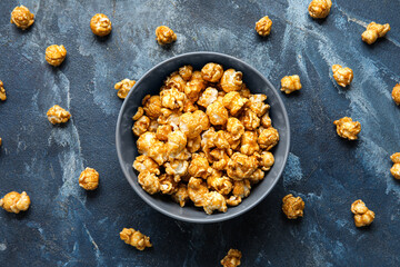 Obraz na płótnie Canvas Bowl with tasty popcorn on blue background