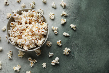 Fototapeta na wymiar Bowl with tasty popcorn on grey background