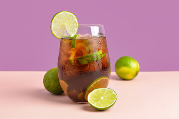 Glass of cold Cuba Libre cocktail on color background