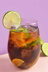 Glass of cold Cuba Libre cocktail on color background