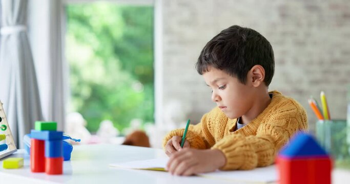 Child, drawing or boy writing homework on notebook in kindergarten education for growth development. Project, creative or young art student with color pencil learning or working on sketching skills