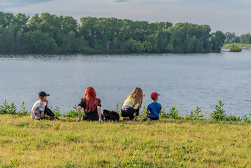 Mother with her children are resting on the riverbank.