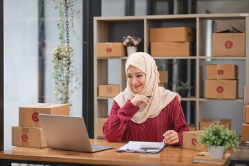 Muslim Woman online store small business owner seller entrepreneur packing package post shipping box preparing delivery parcel on table. Ecommerce drop shipping shipment service concept.