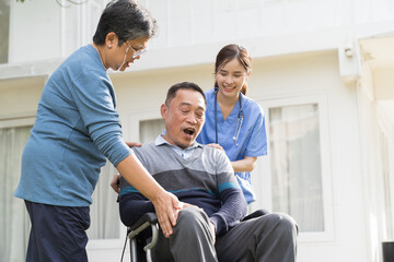 Nurse and patient Asian senior man. Nurse caring Asian senior man on wheelchair outdoor at...