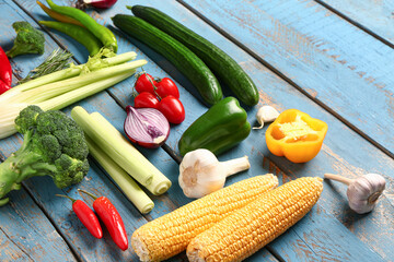 Fresh ripe vegetables on color wooden background, closeup