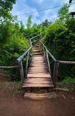 Wooden boardwalk in the green forest. Beautiful hiking trail or footpath across the river. Wooden path, way, track from planks in forest park. Plitvice Lakes, Croatia. Hiking Concept.