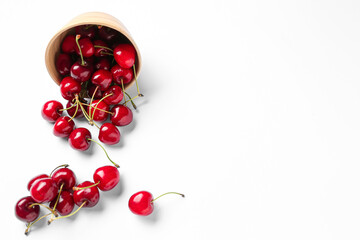Bowl with sweet cherries on white background