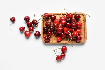 Fototapeta na wymiar Wooden board with sweet cherries on white background