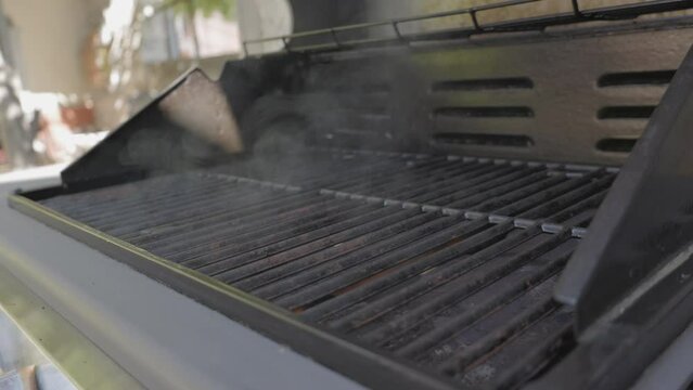 SLO MO Outside grill is turned on and smoke is coming out when it starts to heat up
