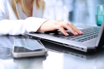 Businesswman is  using a  smartphone and laptop.