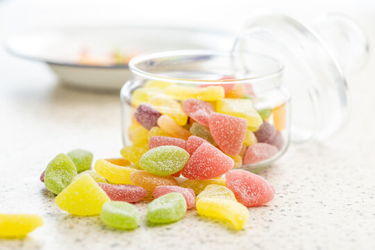Mix of fruity jelly candy in jar on kitchen table.