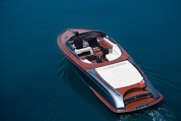 Luxurious big boat for millionaires slow motion on dark blue water top view. Fashion wooden boat...