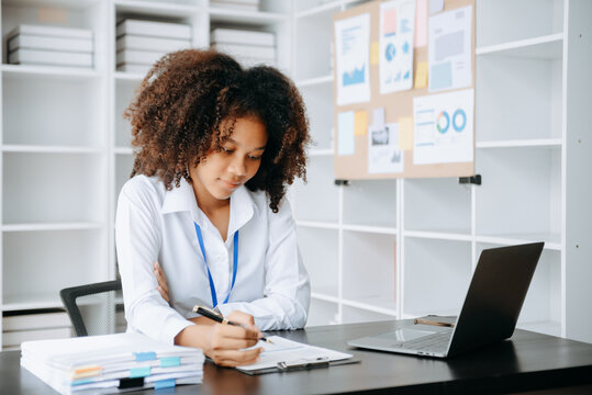 Successful African Businesswoman Analyzing Finance on Tablet and Laptop at modern Office Desk tax, report, accounting, statistics, and analytical research concept..