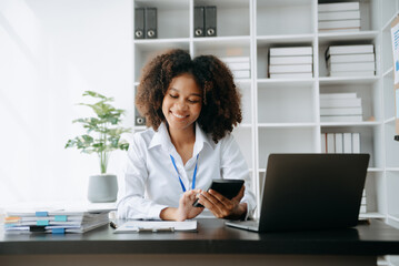 Successful African Businesswoman Analyzing Finance on Tablet and Laptop at modern Office Desk tax, report, accounting, statistics, and analytical research concept..