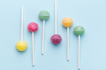 Sweet lollipops and candies on blue background