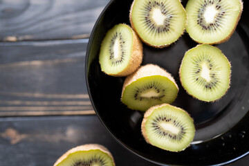 Kiwi, halbiert in einer schwarzen Schale