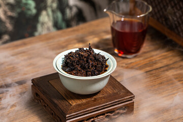 Chinese black tea in a glass cup, traditional tea set, oriental style interior scene, fog formed by dry ice on the table