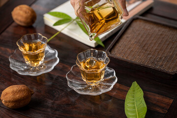 A woman is pouring tea, partial action close-up, Chinese black tea in a glass cup, traditional tea...