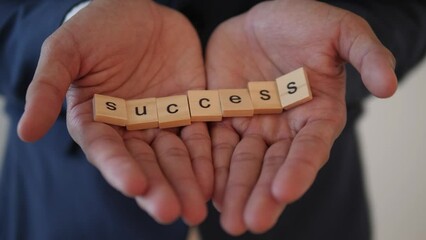 Business Man showing the word success in his hands