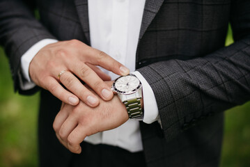 A businessman's husband has a watch on his hand