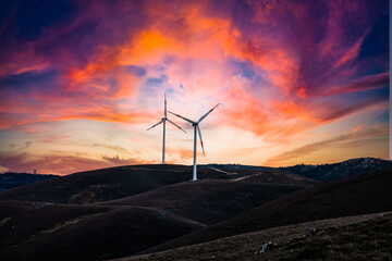 Naklejka na ściany i meble A wind farm or wind parkwith turbines at sunset clouds located in the mountains of Italy Europe and it allows to realize clean energy. It’s sustainable, renewable energy 