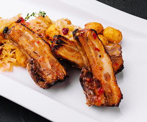 Pickled cabbage with fried pork ribs and spicy potatoes on a plate
