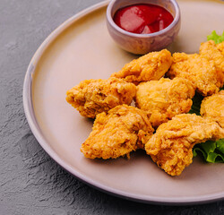 Delicious crispy fried chicken breast strips with tomato sauce