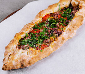 traditional turkish meat pide on wooden board