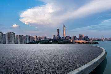 Asphalt road platform and city skyline with modern building at sunset in Suzhou, Jiangsu Province, China.