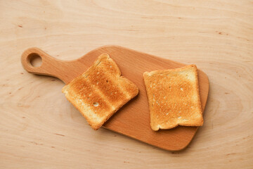 Two appetizing toasts on a wooden board, top view