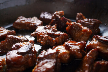 Close-up delicious fried meat in a frying pan, home cooking
