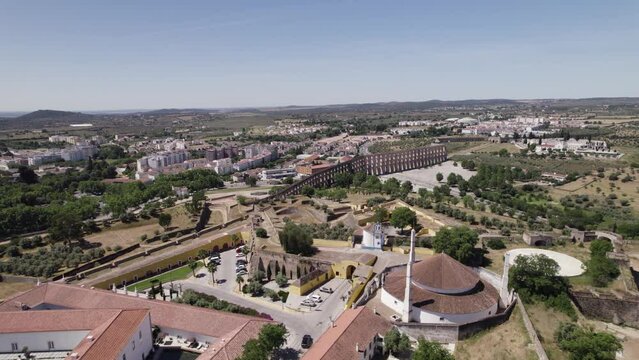 Aerial View Over Our Lady Of Conception Church In Elvas With Amoreira Aqueduct In Background. Circle Dolly Shot