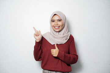 Attractive Asian woman wearing casual clothes smiling and pointing with two hands to the side