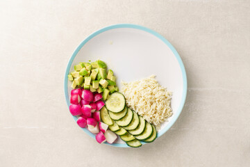 Raw vegetables with salmon and rice on a large platter, health bowl, top view