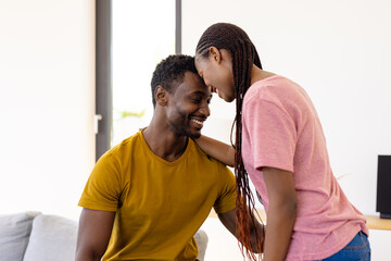 Happy african american couple embracing in living room