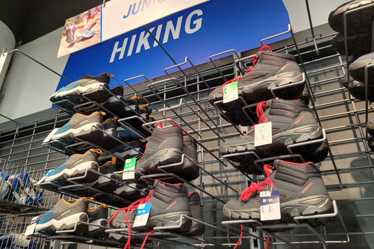 PENANG, MALAYSIA - 18 JUNE 2023: Interior view of Hiking shoes display on shelf in Decathlon store. It is a French sporting goods retailer,  with over 2080 stores in 56 countries and regions.