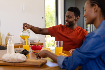 Happy african american couple enjoying breakfast in dining room