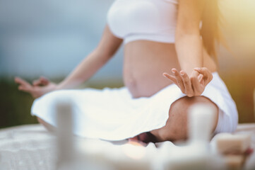 Prenatal care and pregnancy concepts of motherhood. Pregnant woman yoga relaxing and breathing the air and enjoying the baby by the river in the morning.