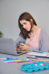 Artist and entrepreneur woman working in a laptop. Unique clothing designer.