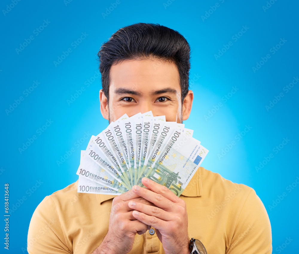 Canvas Prints Money, winner and man cover face isolated on blue, studio background for winning, cash fan or financial loan. Lottery, bank and asian person winning bonus, budget secret or finance profit in portrait