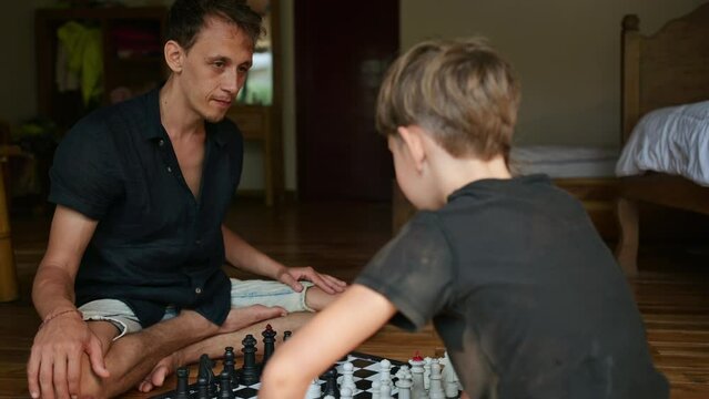 Father plays chess with his son